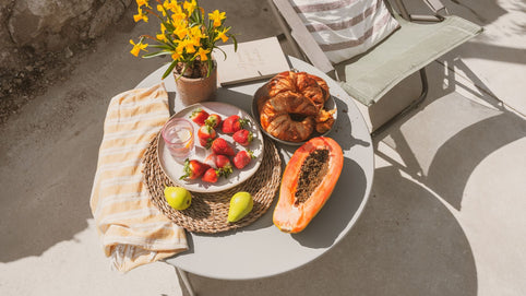 Soft summer flatlay, colorful bowl of fresh seasonal fruits and vegetables, warm golden light, linen texture, wellness lifestyle photography, earthy tones influence of seasonal  Variations  on your gut