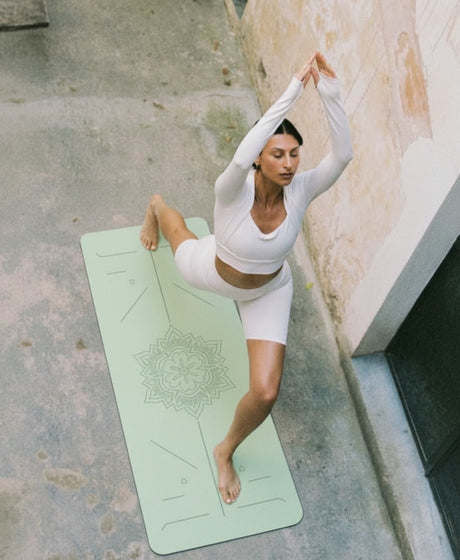 Natuurlijke yogamat met positielijnen in terracotta kleur in lichte yogastudio, ideaal voor yoga thuis of in de studio.