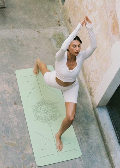 Natuurlijke yogamat met positielijnen in terracotta kleur in lichte yogastudio, ideaal voor yoga thuis of in de studio.