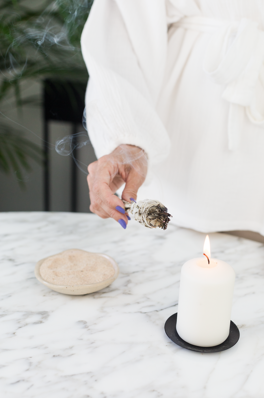 Rustige setting met kaars en witte salie voor een beschermend huisritueel