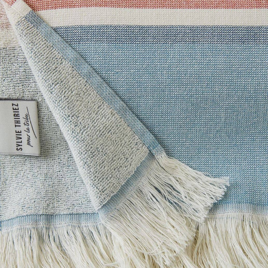 detail van blauw gestreept strandlaken met franjes