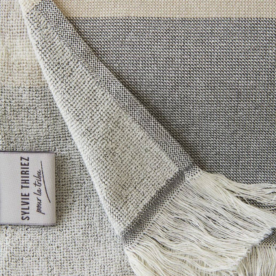 detail van grijs gestreept strandlaken met franjes