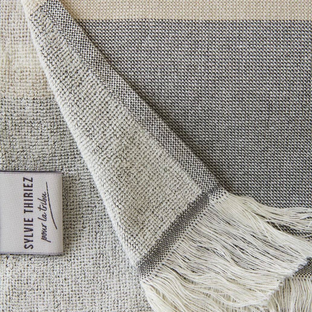 detail van grijs gestreept strandlaken met franjes