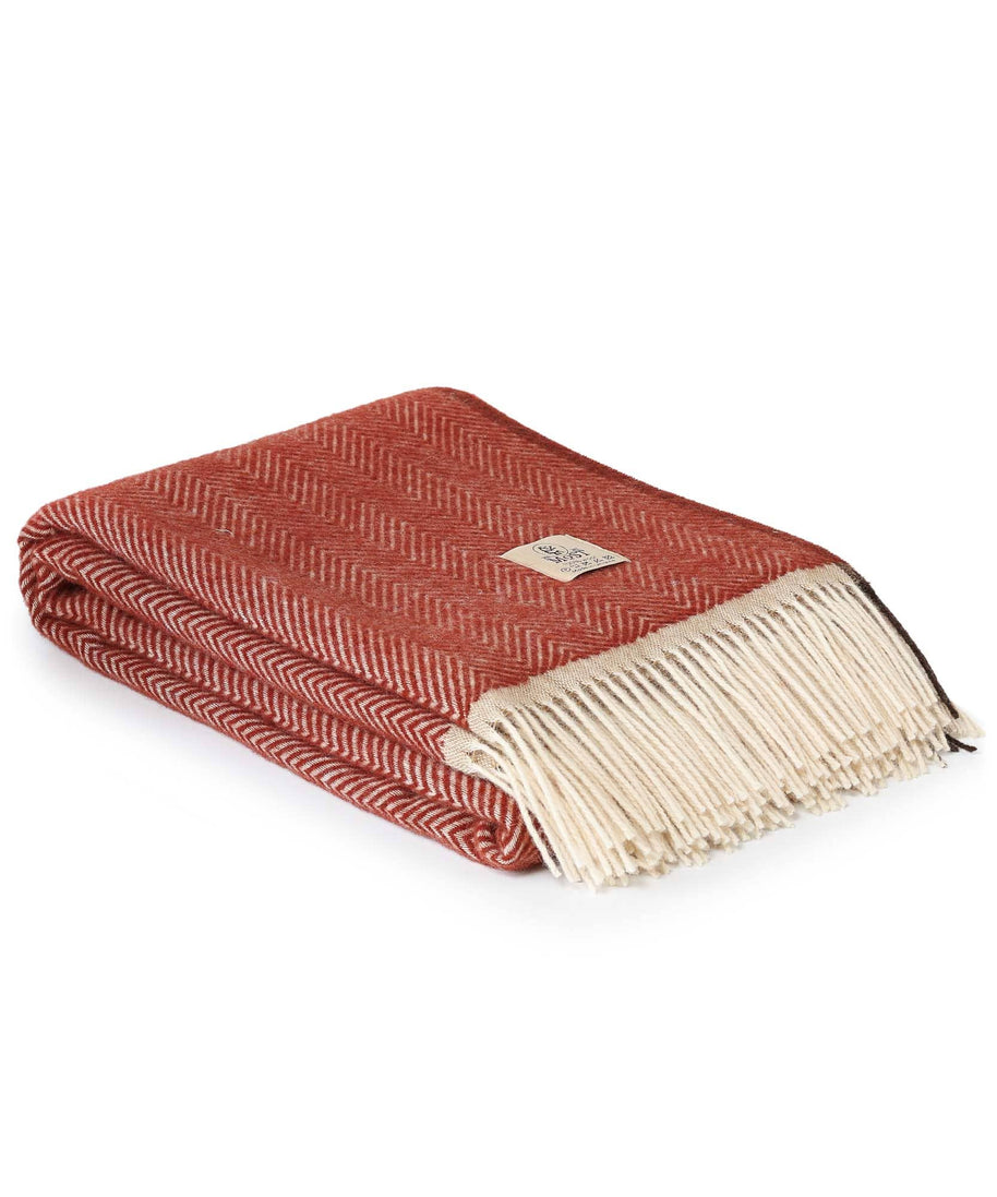 rode wollen plaid opgevouwen met franjes en zigzagpatroon