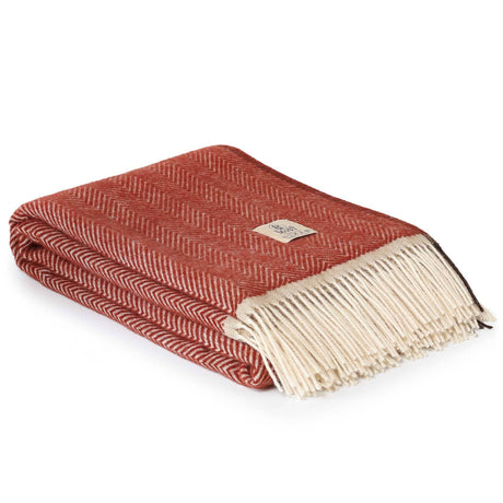 rode wollen plaid opgevouwen met franjes en zigzagpatroon