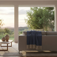 Blauwe kasjmier-merinowollen plaid gebruikt in een rustige, warme leefomgeving