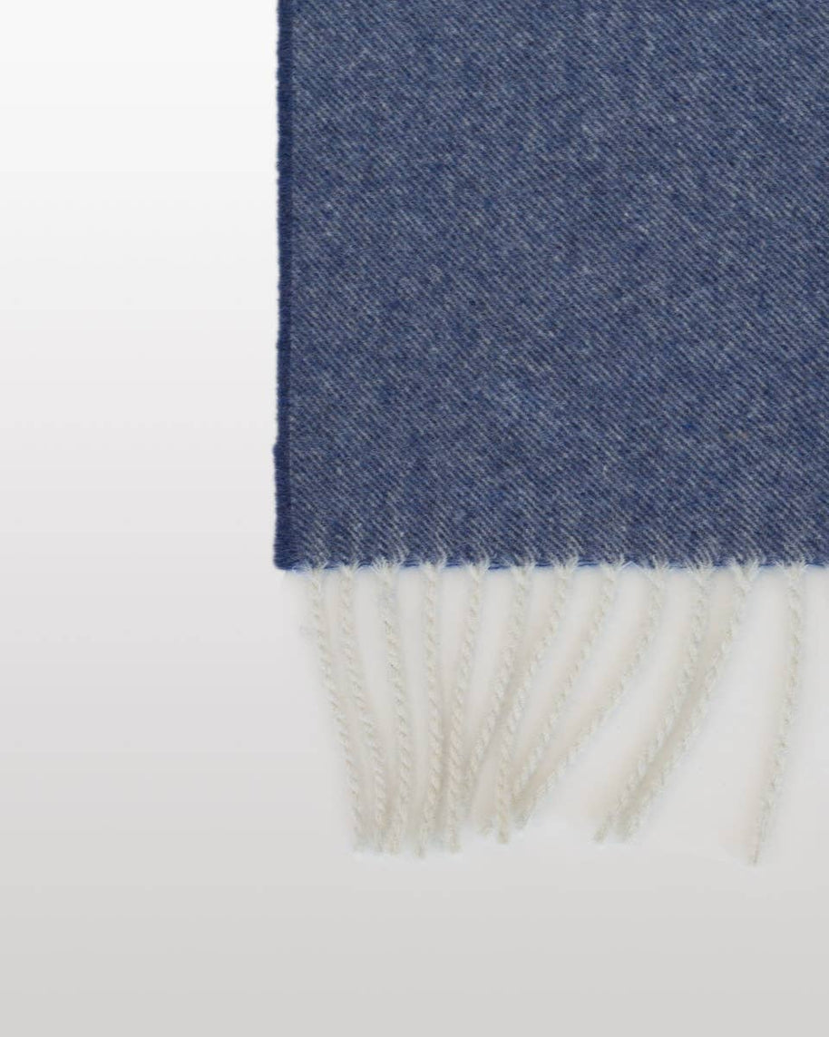 Detail van de rand en franjes van een blauwe kasjmier-merinowollen plaid