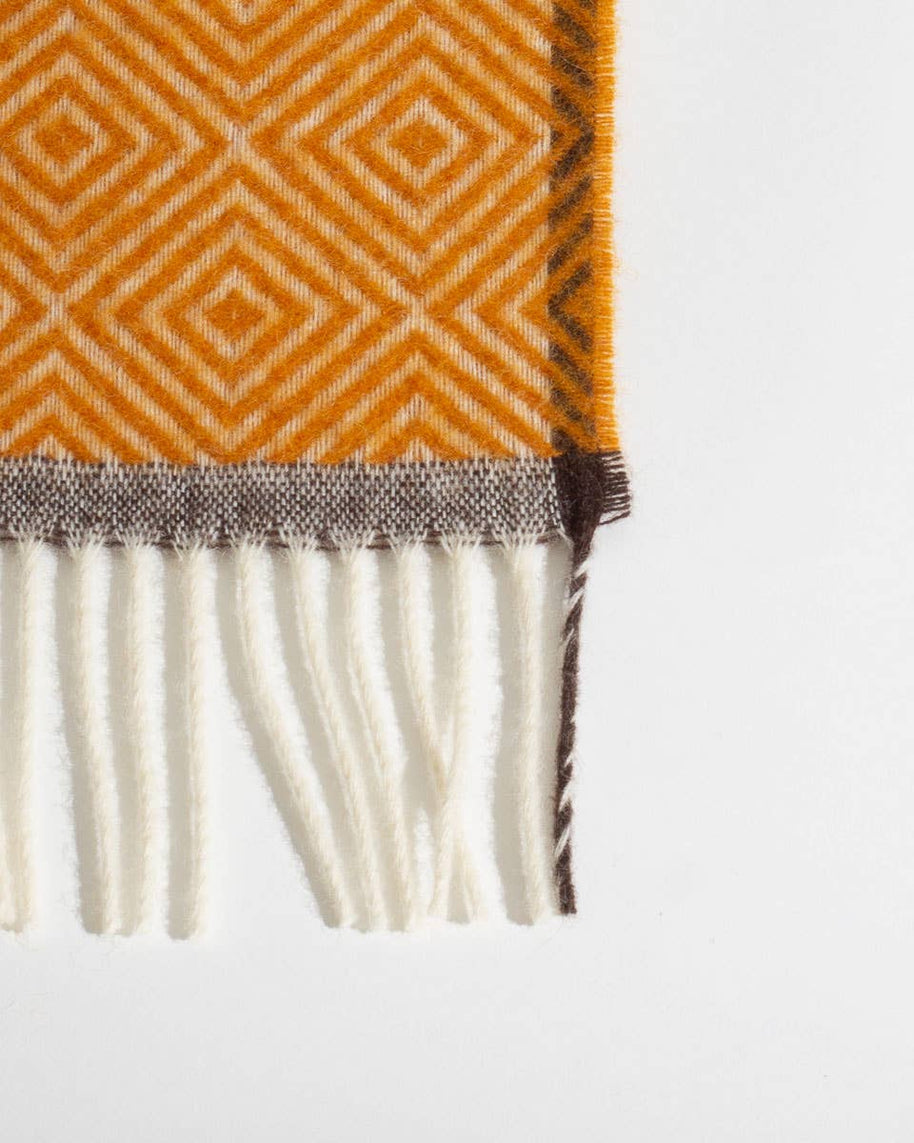 Detail van de rand en het patroon van een warmgele wollen deken
