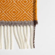 Detail van de rand en het patroon van een warmgele wollen deken