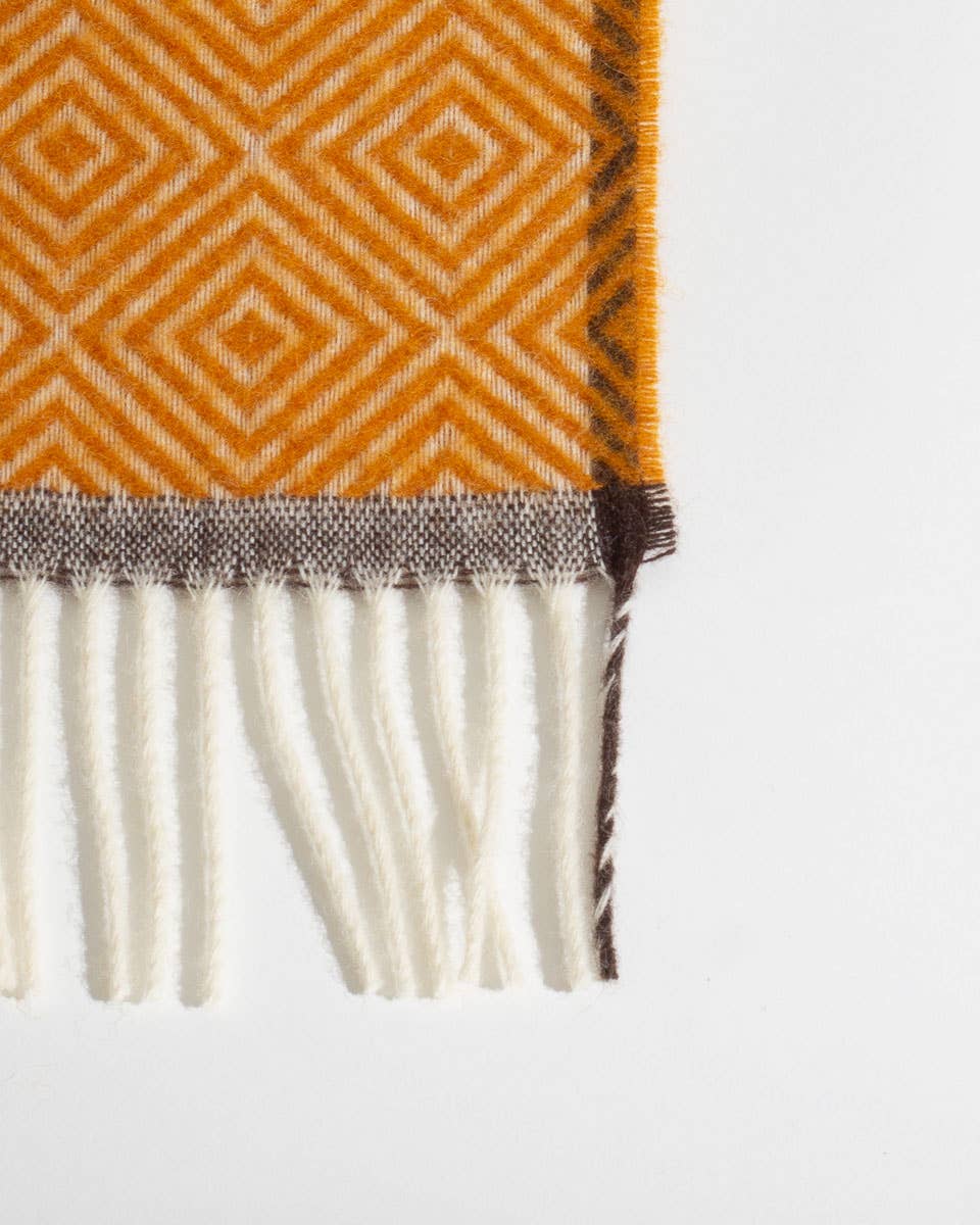 Detail van de rand en het patroon van een warmgele wollen deken