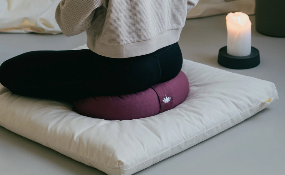 Halvemaan meditatiekussen gebruikt tijdens meditatie in rustige ruimte