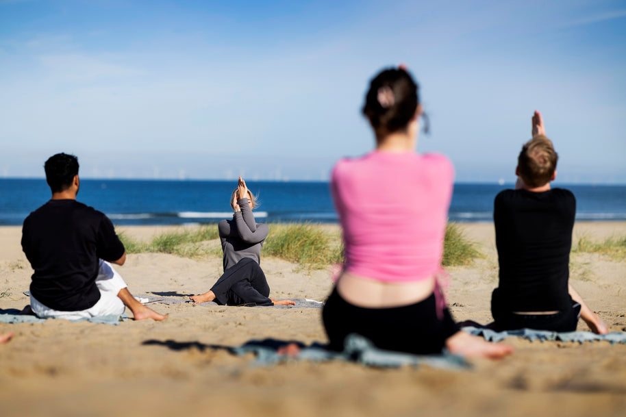Strand yoga les op het Zuiderstrand in Scheveningen met deelnemers op yogamatten
