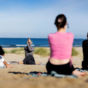 Strand yoga les op het Zuiderstrand in Scheveningen met deelnemers op yogamatten