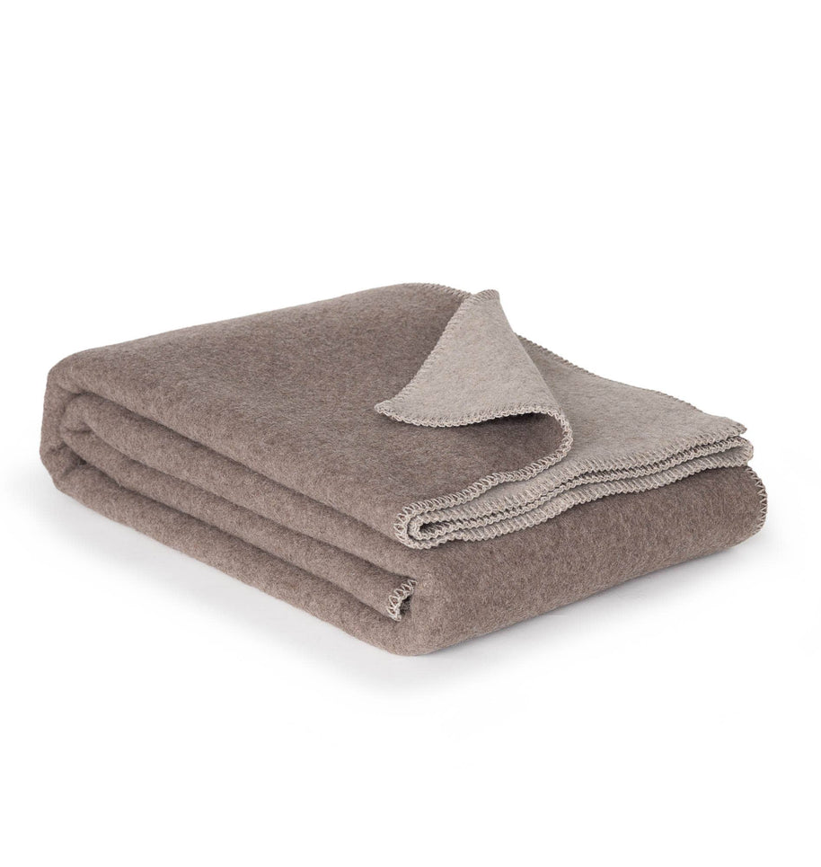 Merinowollen deken in bruin en beige netjes gevouwen met zachte afwerking