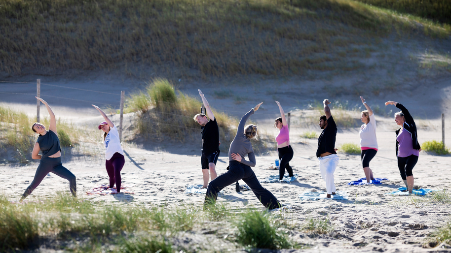 Strand yoga flow in kleine groep op het strand van Scheveningen in de ochtendzon