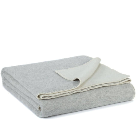 Opgevouwen wollen beddeken in grijs met zachte violette ondertoon van Nieuw-Zeelandse wol