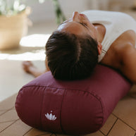 Vrouw die ontspant op een rechthoekige yoga bolster tijdens rustmoment lotuscraft