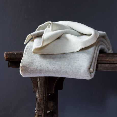 Wollen beddeken in grijs violet nonchalant gedrapeerd in een rustige setting