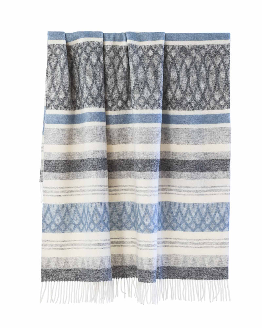 Wollen plaid in blauw en beige hangend, met zachte strepen en franjes