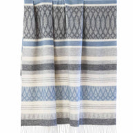 Wollen plaid in blauw en beige hangend, met zachte strepen en franjes