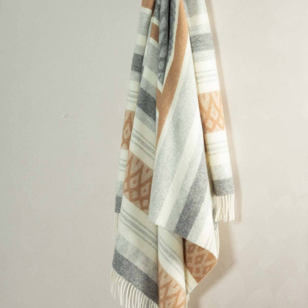Wollen plaid van Nieuw-Zeelandse wol hangend aan de muur met zachte, natuurlijke kleuren