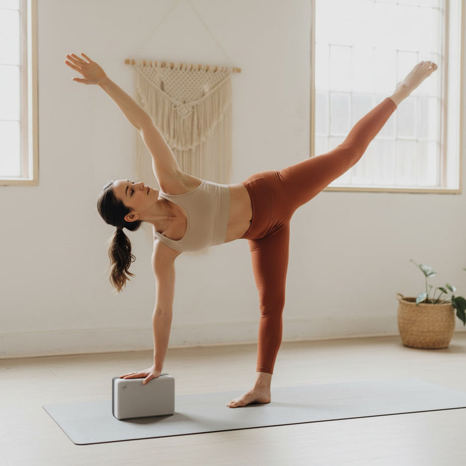 Klassieke antracietgrijze foam yoga brick met een stevige grip voor ondersteuning bij balanshoudingen en stretches.