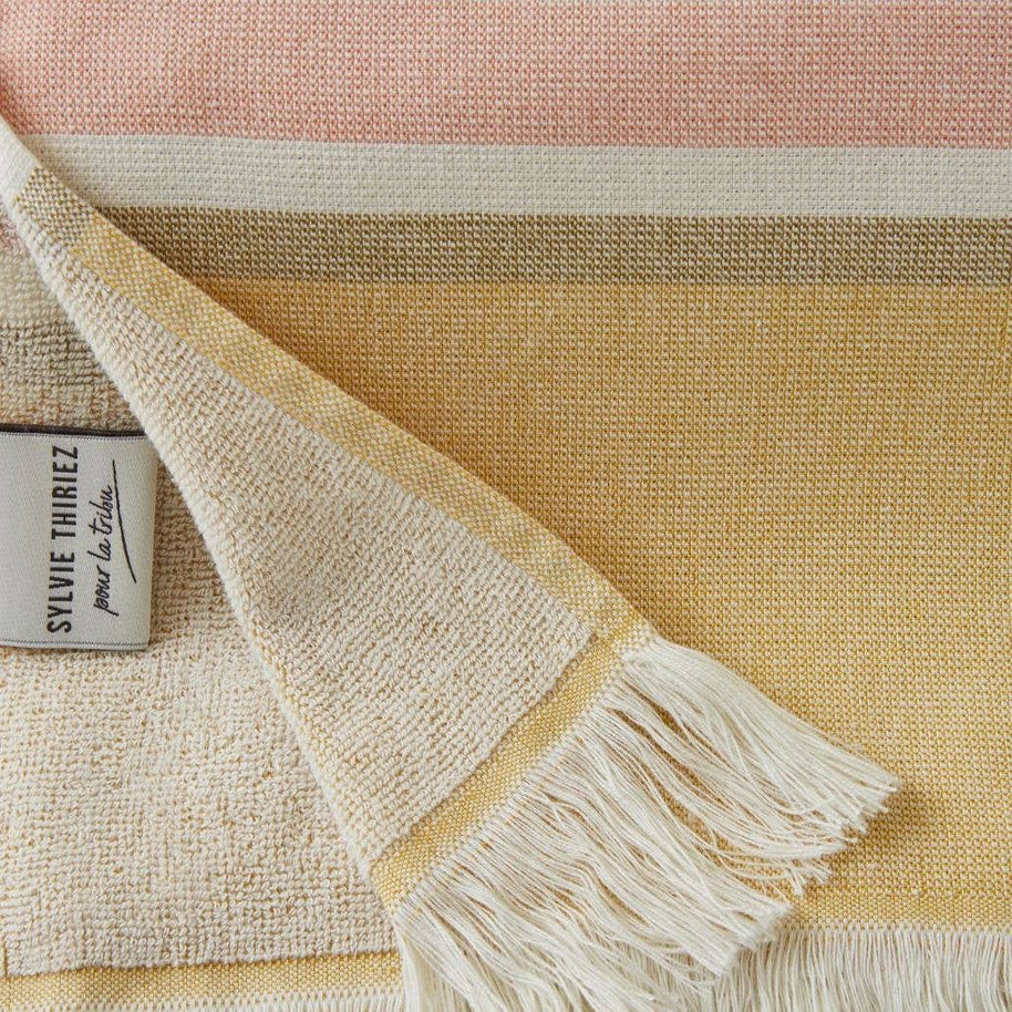 detail van geel gestreept strandlaken met franjes