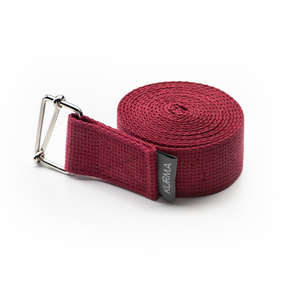 Overzichtsfoto van de lange katoenen Evolve yogariem in rood burgundy rood met metalen sluiting tegen een rustige, lichte achtergrond.