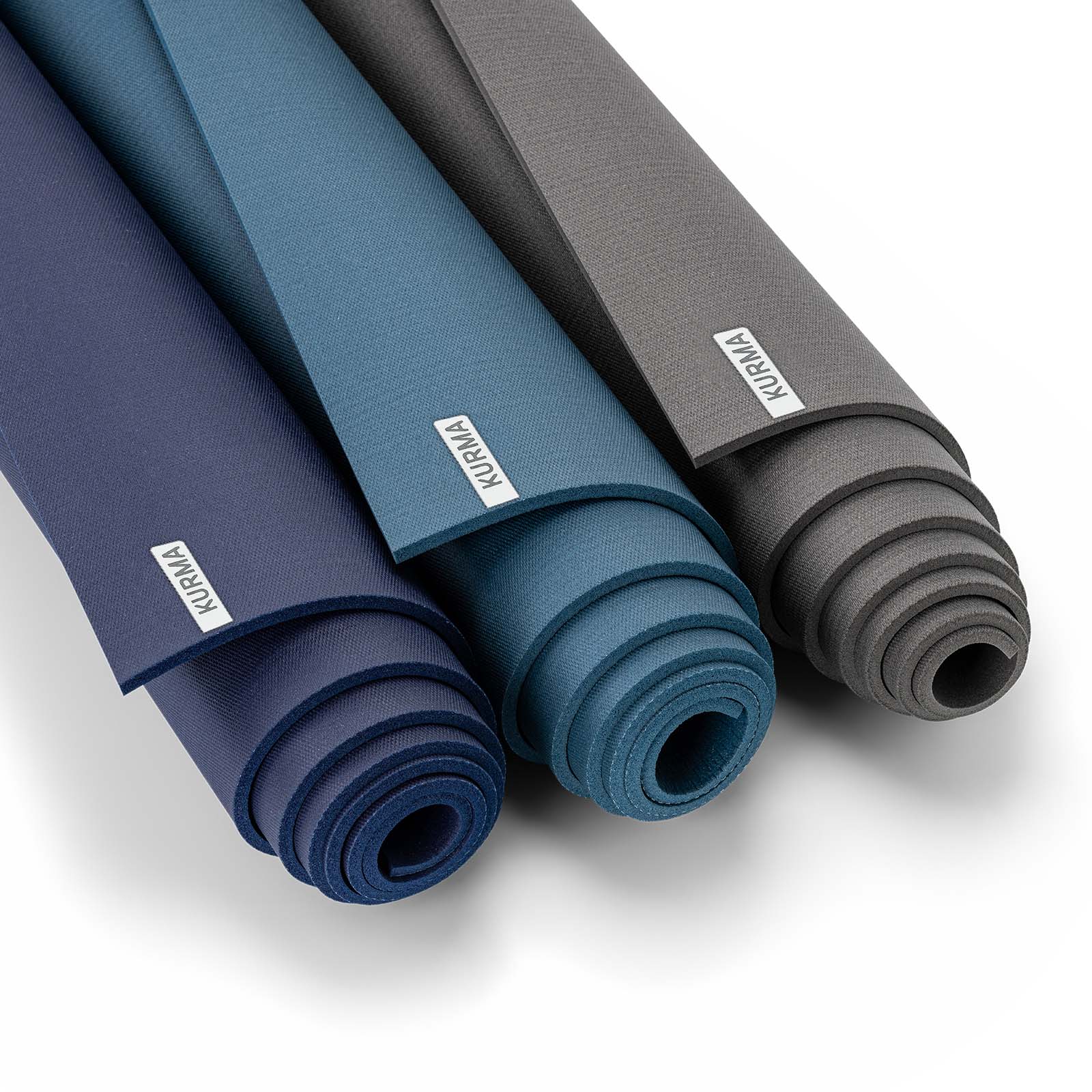 Drie opgerolde CORE yogamatten in de kleuren blauw, petrol en grijs, tonend dat er voor elk interieur een passende aardse tint is.