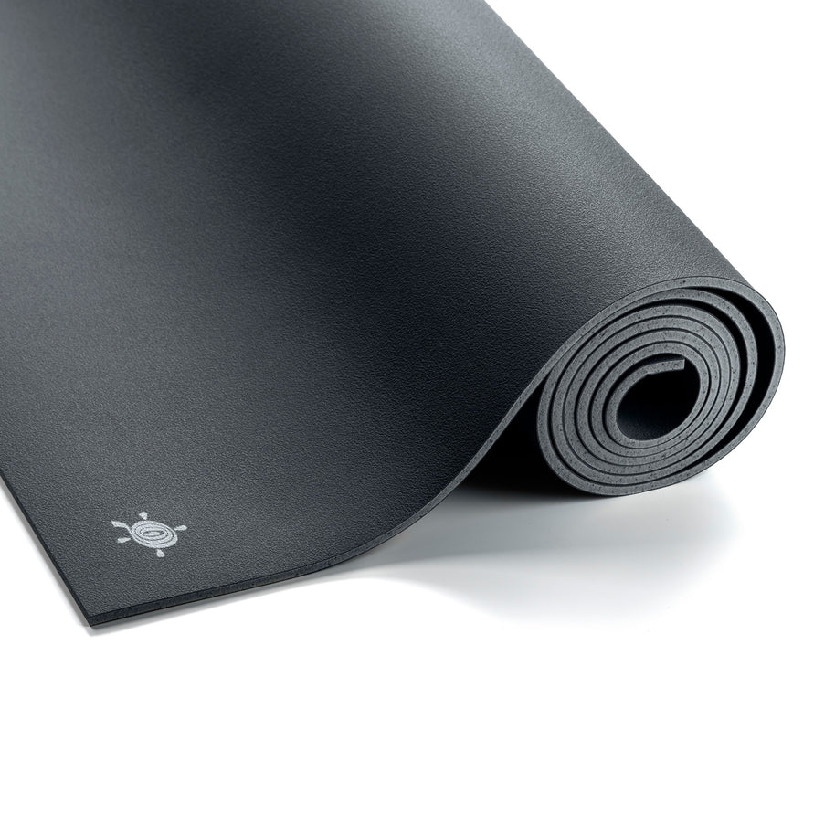 Antracietgrijze GECO rubber yogamat van Ground to Glow uitgerold op een lichte vloer, gemaakt van duurzaam natuurrubber voor optimale grip en demping tijdens yoga.