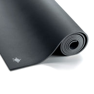 Antracietgrijze GECO rubber yogamat van Ground to Glow uitgerold op een lichte vloer, gemaakt van duurzaam natuurrubber voor optimale grip en demping tijdens yoga.