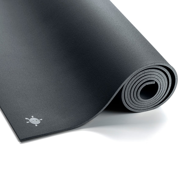 Antracietgrijze GECO rubber yogamat van Ground to Glow uitgerold op een lichte vloer, gemaakt van duurzaam natuurrubber voor optimale grip en demping tijdens yoga.