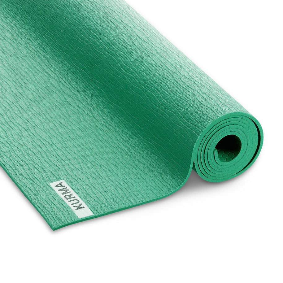 Groene SHIFT yogamat opgerold met antislip structuur zichtbaar