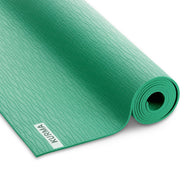 Groene SHIFT yogamat opgerold met antislip structuur zichtbaar