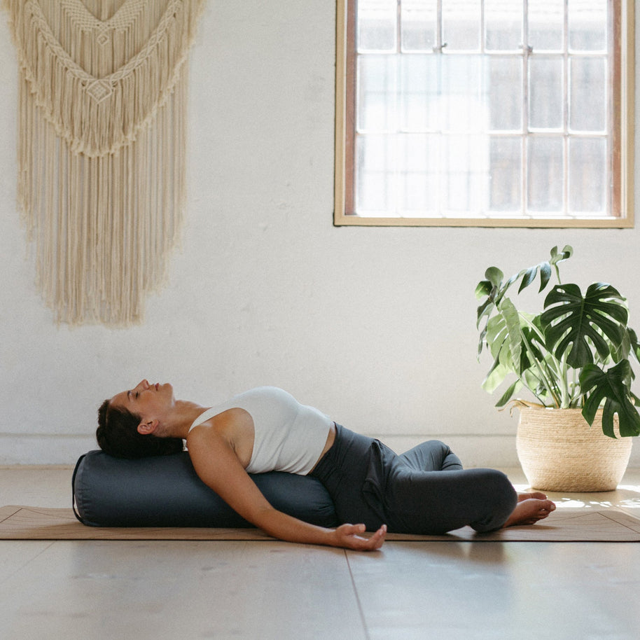 restorative yoga met bolster onder rug