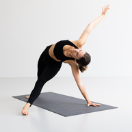 Yogi op Yoga Mat MUDRA Studio in staande twist