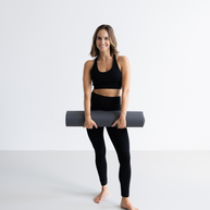Yogi draagt lichte yogamat naar de studio