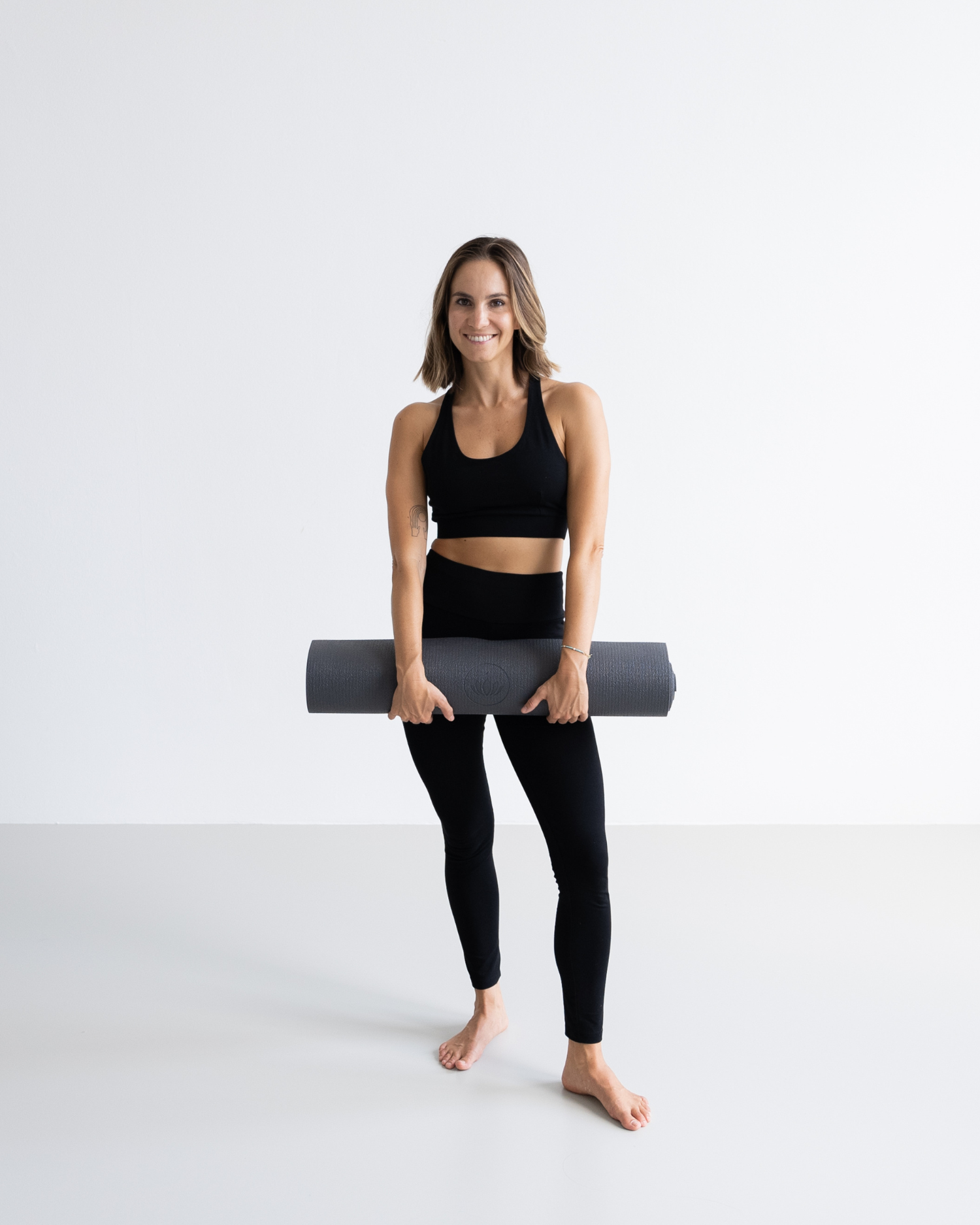 Yogi draagt lichte yogamat naar de studio