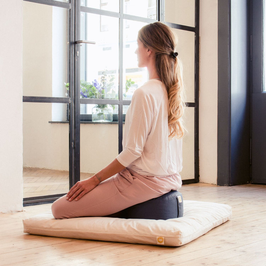 Yogi mediteert op meditatiekussen van 15 cm hoog