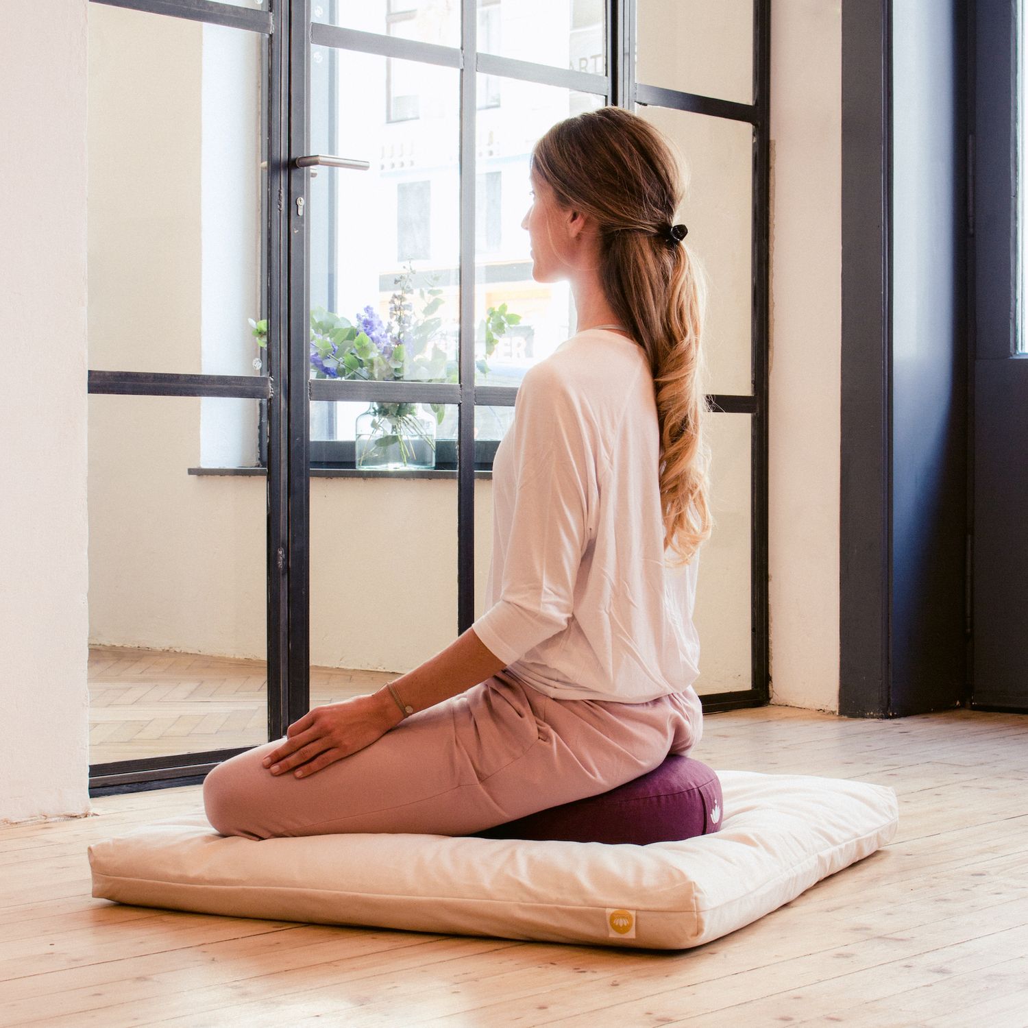 Yogi zit op laag meditatiekussen tijdens meditatiemoment